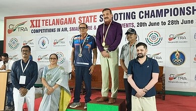 Former Telangana DGP wins gold at state shooting championship, standing on podium with medal.