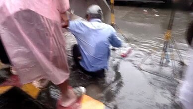 Mumbai civic worker falls into water channel during inspection, water splashing around.