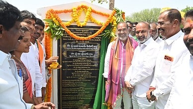 Politicians and officials unveiling a commemorative plaque at an outdoor event in India.