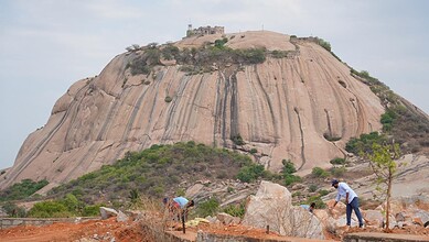 Bhongir Fort with rocky slopes and visitors exploring the area.