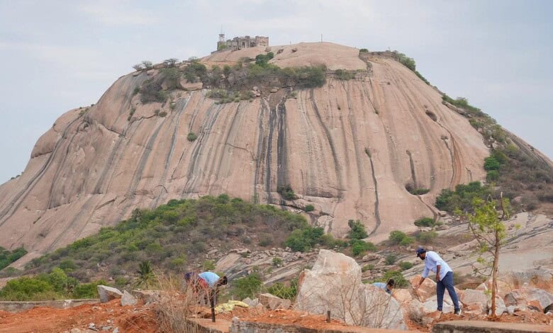 Bhongir Fort with rocky slopes and visitors exploring the area.