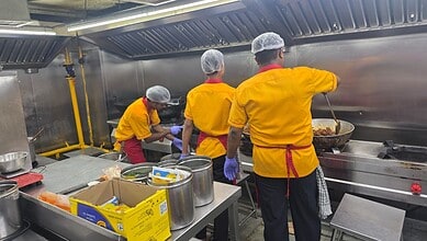 Biryani chefs cooking in a professional kitchen at Kondapur outlet in Hyderabad.