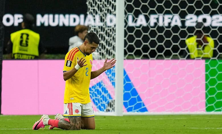 Colombia football player kneeling and praying on the field after match.