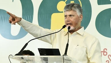 A man speaking at a podium during a public event, gesturing with his right hand.
