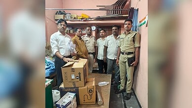 A group of men, including a police officer, standing inside a small room with boxes and supplies, possibl.