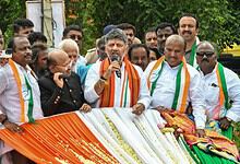 Indian political leaders celebrating Independence Day, holding a flag and addressing a crowd.