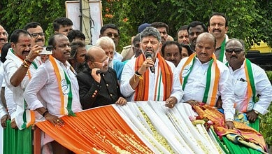 Indian political leaders celebrating Independence Day, holding a flag and addressing a crowd.
