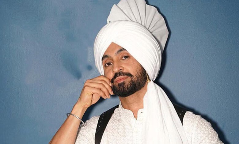 A traditional Sikh man wearing a white turban and beard, posing confidently against a blue background.