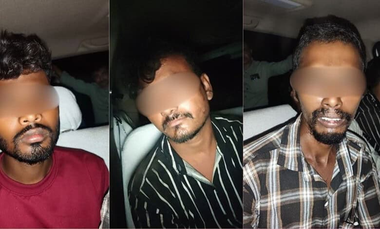 Three men with blurred faces sitting in a vehicle, wearing casual shirts.