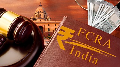 Gavel, FCRA India book, and Indian currency notes on a table.