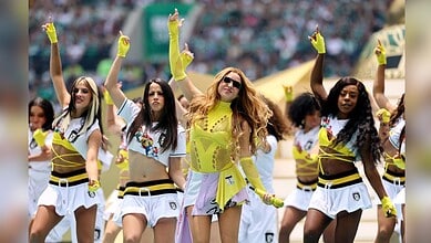 Vibrant cheerleaders performing on field during sports event with energetic dance moves and colorful outf.