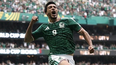 Mexican footballer in green jersey with number 9, expressing joy during a match at the stadium.