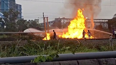 Fire explosion at Haldia plant after pipeline leak, with people nearby and smoke rising.