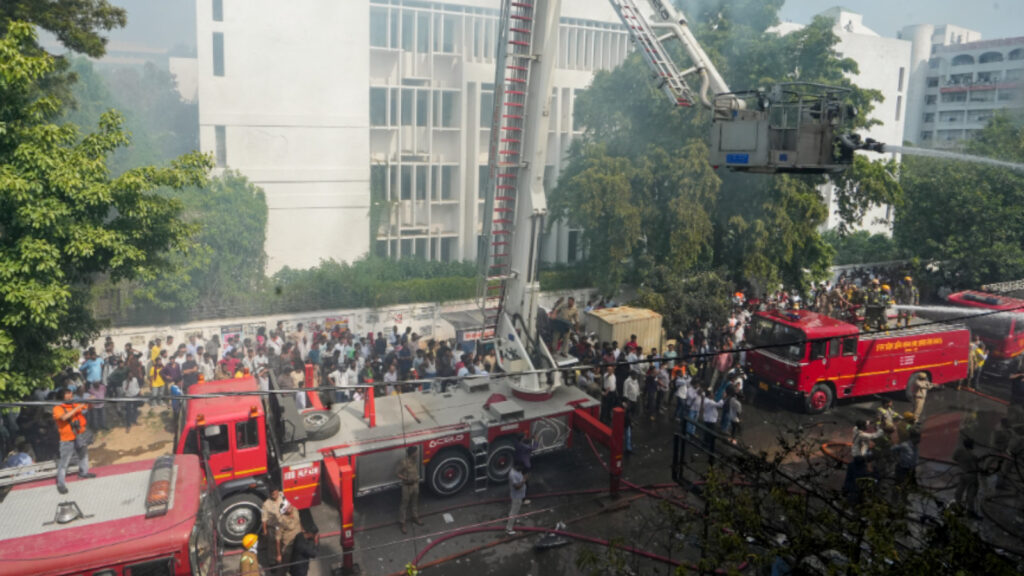 Fire personnel conduct a dousing operation after fire broke out at a commercial building in Aliganj, Lucknow