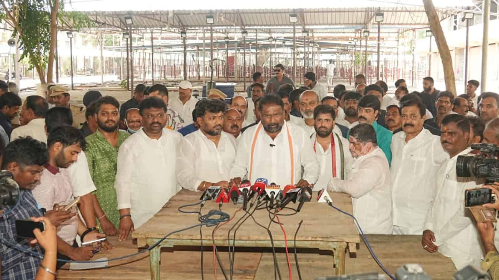The Siasat Daily: Politician addressing media and supporters at a press conference with microphones and c.