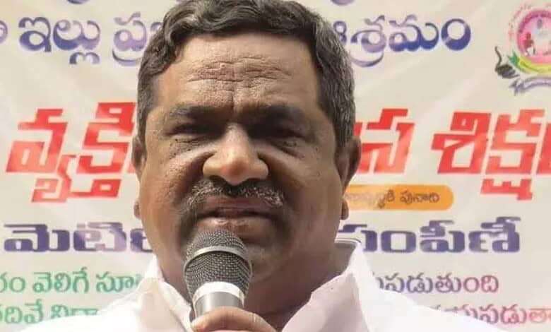 A man speaking into a microphone at a public event with a colourful banner in the background.