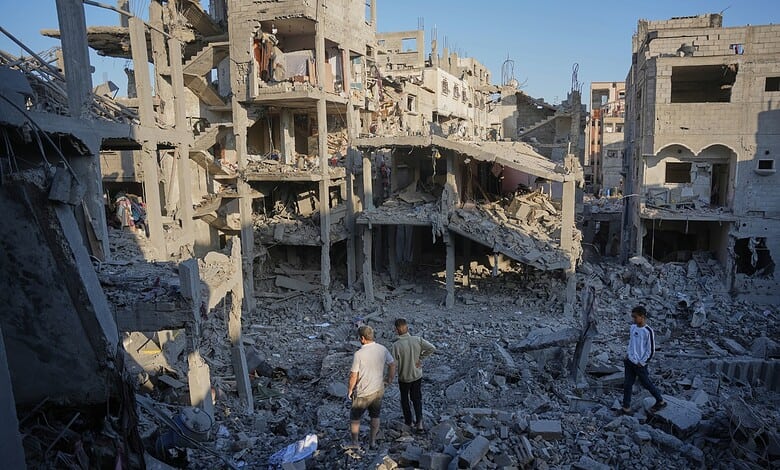 Destruction in a war-torn urban area with damaged buildings and debris, showing civilians walking through.