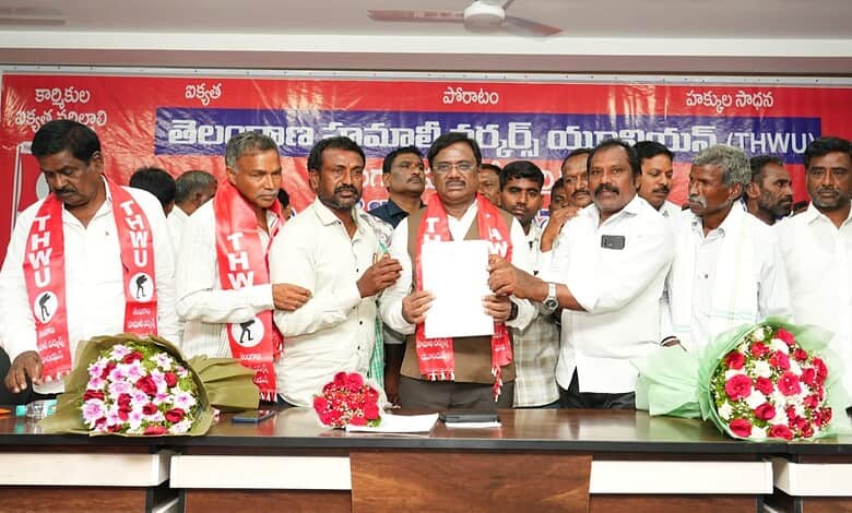 Telangana government officials and representatives at a formal event with flower bouquets and banners.