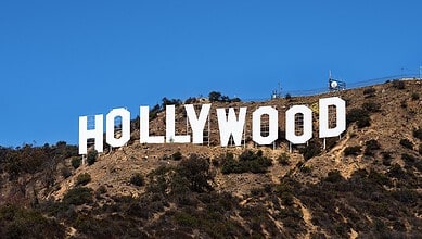 Iconic Hollywood sign on the hillside under a clear blue sky.