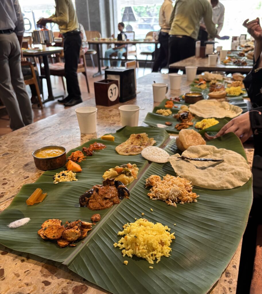 Traditional Indian thali with rice, curries, bread, and side dishes served on banana leaves in a restaura.
