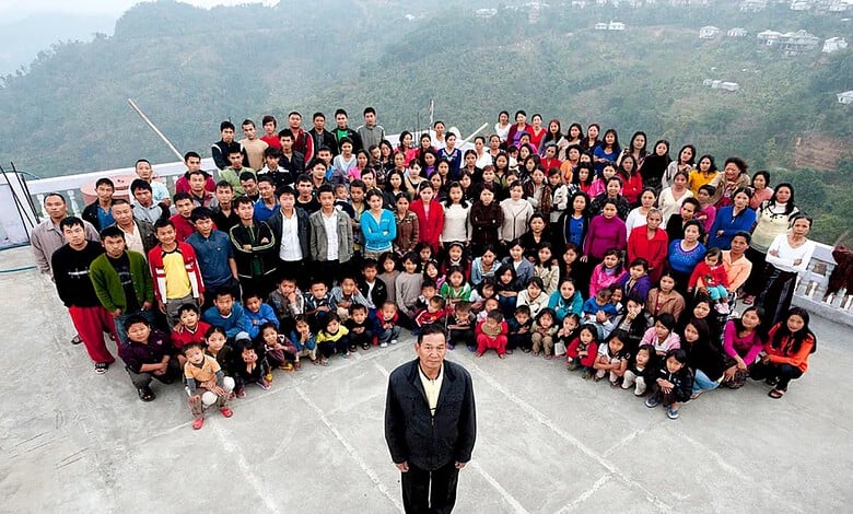 Group of diverse people gathered outdoors on a mountain terrace, posing for a photo.