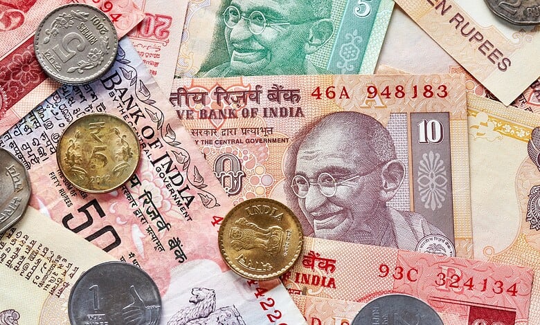 Indian currency notes and coins, including rupees and paise, on a surface.