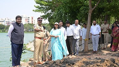 Community leaders and officials gather by the water for an environmental event in Hyderabad.