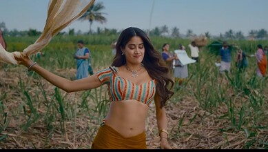 Woman dancing joyfully in a vibrant field with farmers and greenery in the background.