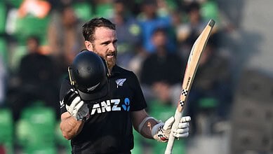 A cricket player celebrating after scoring a century during a match.