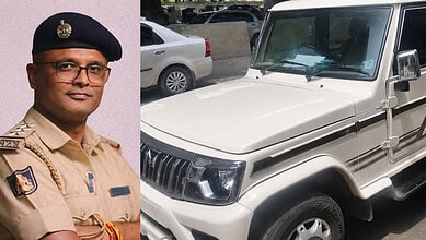 Kerala police officer in uniform standing next to a white vehicle.