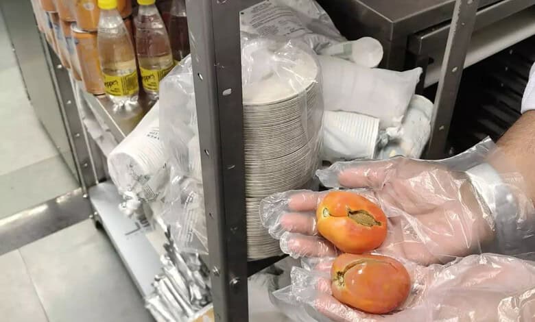 Person handling tomatoes with gloves in a food safety inspection setting.