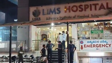 Hospital entrance with medical staff and patients outside.