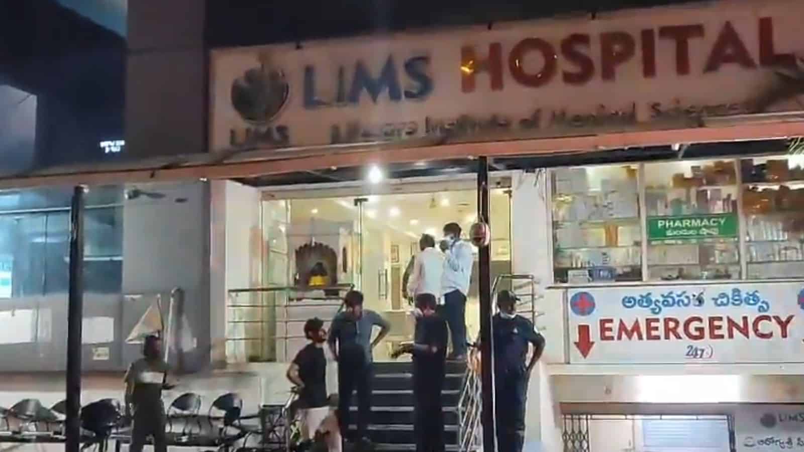 Hospital entrance with medical staff and patients outside.