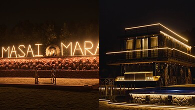 Illuminated sign reading "MASAI MARA" at night with visitors in front, showcasing a popular safari destin.