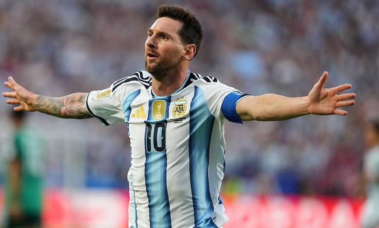 Lionel Messi celebrating with arms outstretched during a match in Argentina's national team jersey.