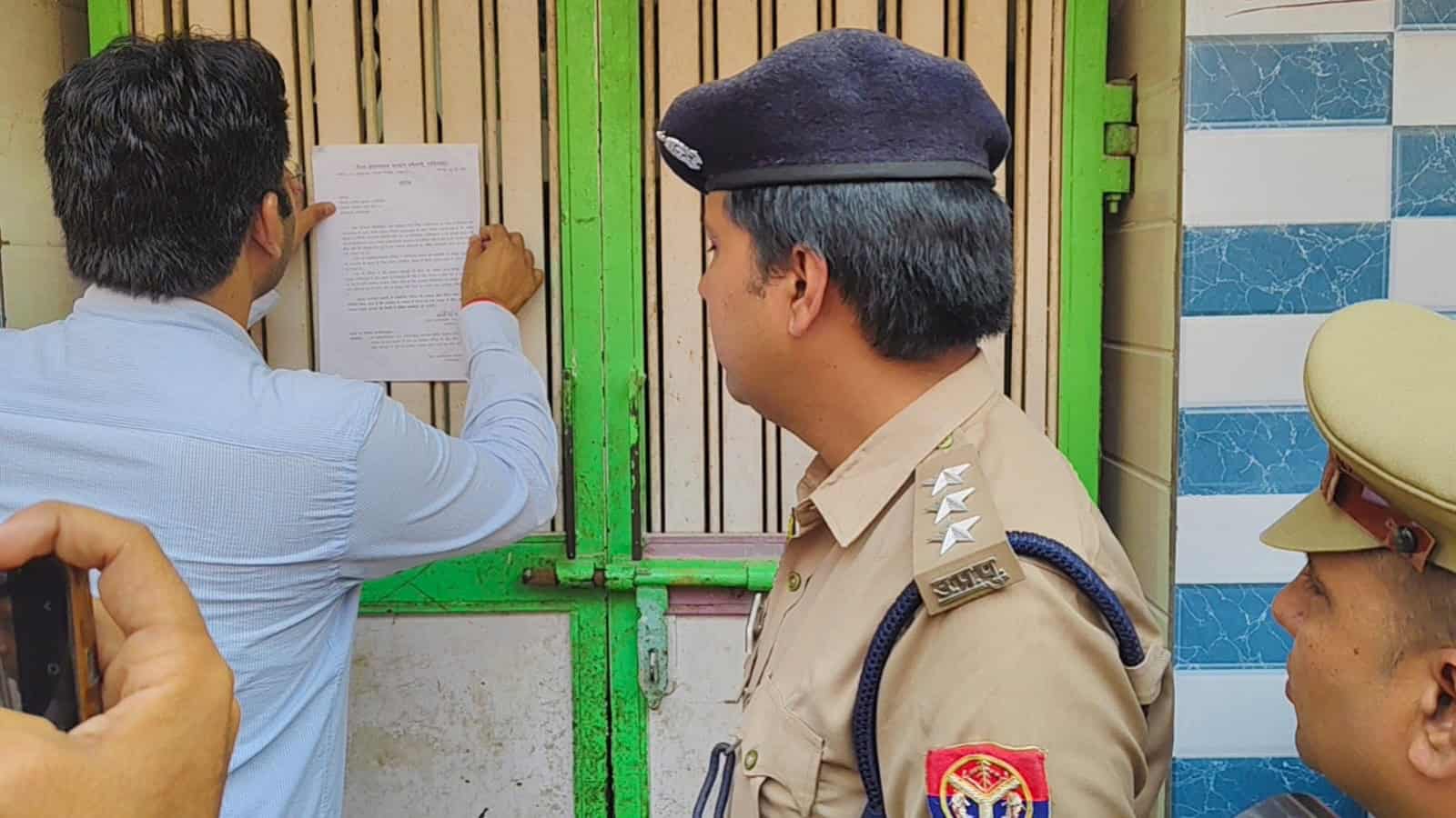 A man in civilian clothes showing documents to police officers at a security checkpoint.