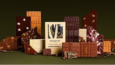 Delicious assorted chocolates with various flavours and textures displayed on a dark background.