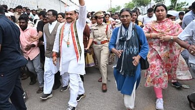 Politicians and officials participating in a political rally or procession outdoors.