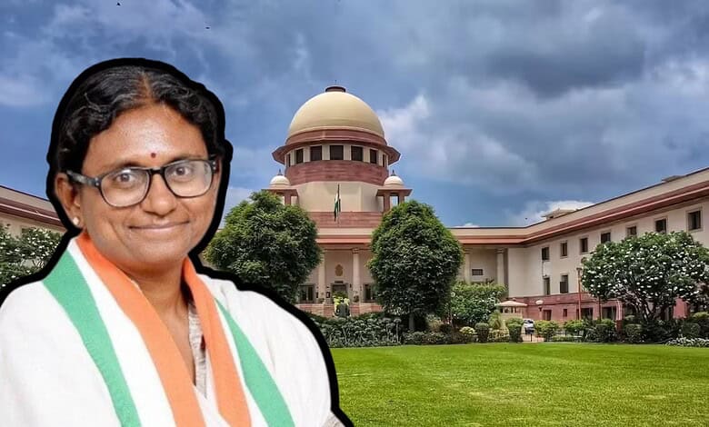 Prominent Indian woman in traditional attire standing in front of the Supreme Court of India.