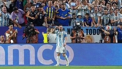 Lionel Messi celebrates his hat trick as Argentina wins 3-0 against Algeria in a football match.