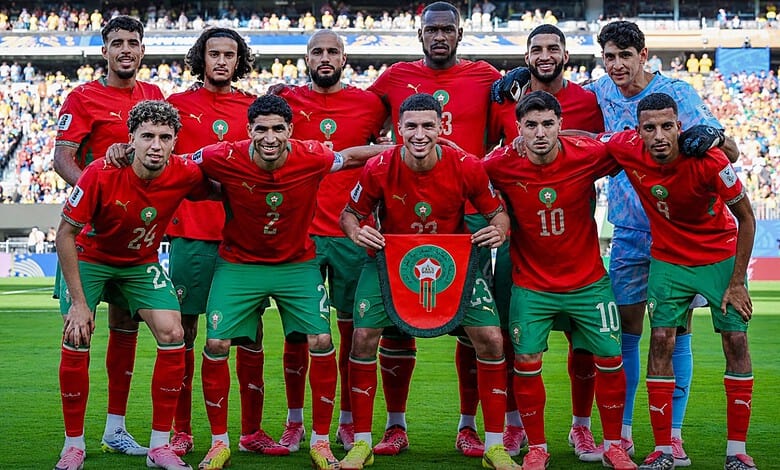 Moroccan football team in red jerseys on the field during a match at the FIFA World Cup.