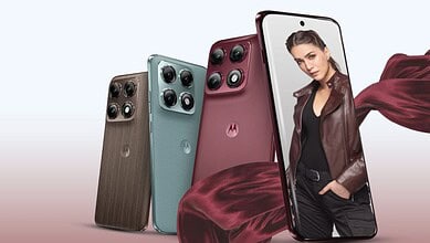 A woman holding a smartphone with multiple camera lenses, showcasing new mobile phone models.