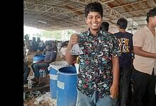 A boy display a fish at the Fish Prasadam event in Hyderabad