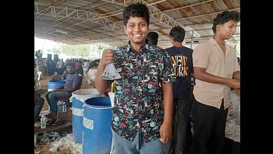 A boy display a fish at the Fish Prasadam event in Hyderabad