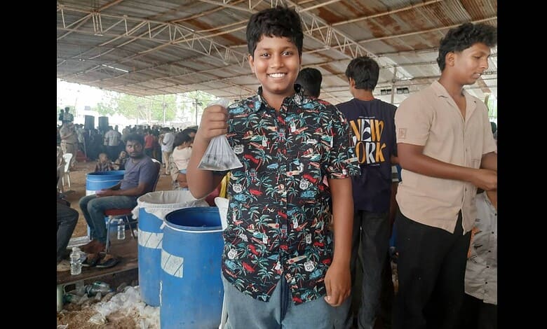 A boy display a fish at the Fish Prasadam event in Hyderabad