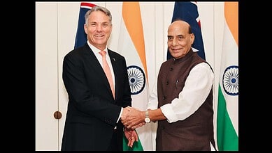 Diplomatic meeting between two leaders with Indian flags in the background, showcasing international rela.