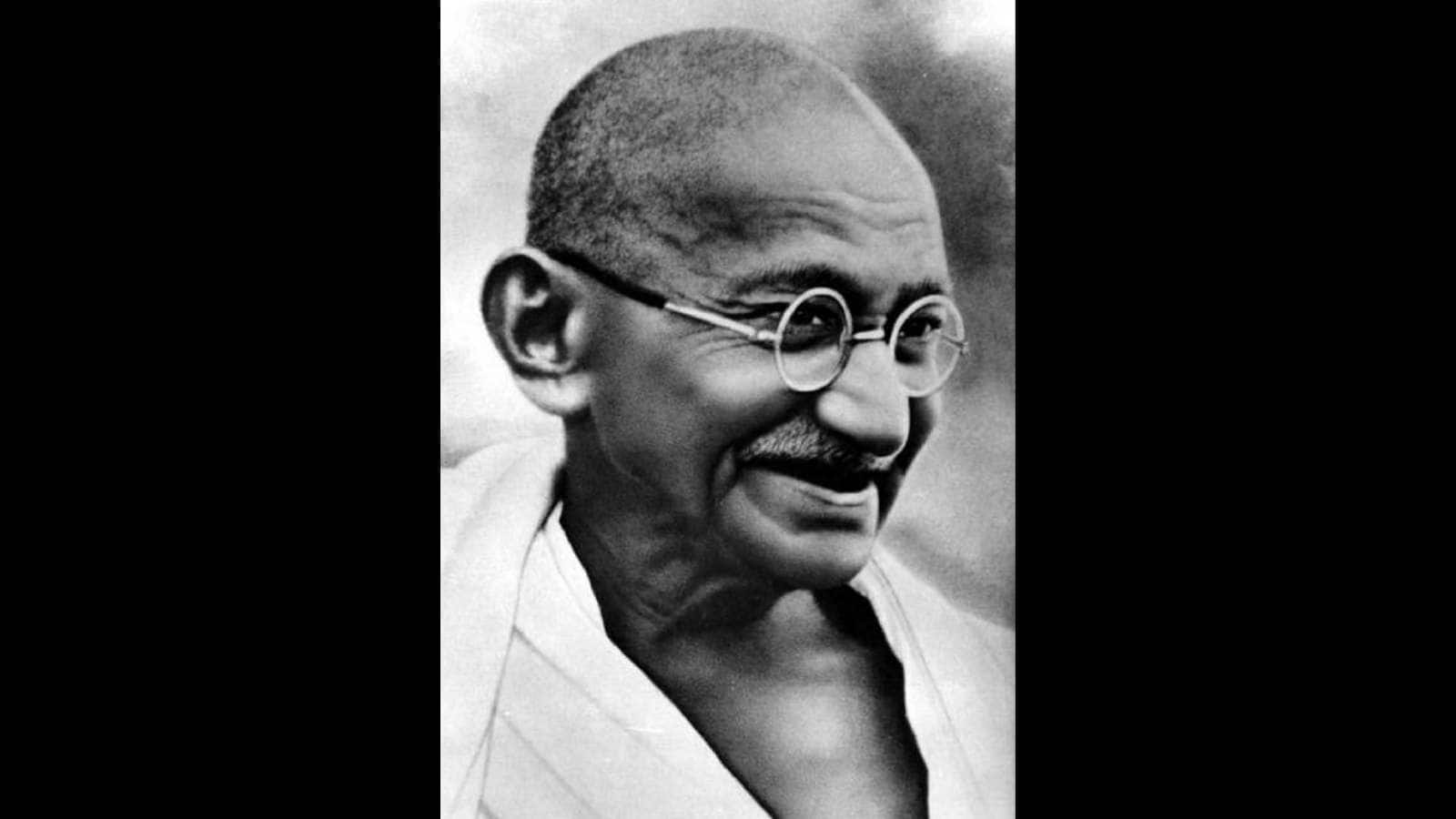 Mahatma Gandhi portrait in black and white, showcasing his iconic glasses and peaceful expression.