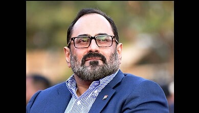 Kerala BJP Chief in a blue suit and glasses during a public event.