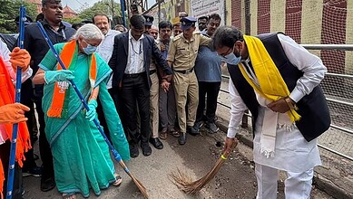 Officials and citizens participate in a street cleaning event for the Clean India initiative.
