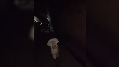 Child walking alone in a dark alley at night with a white T-shirt.